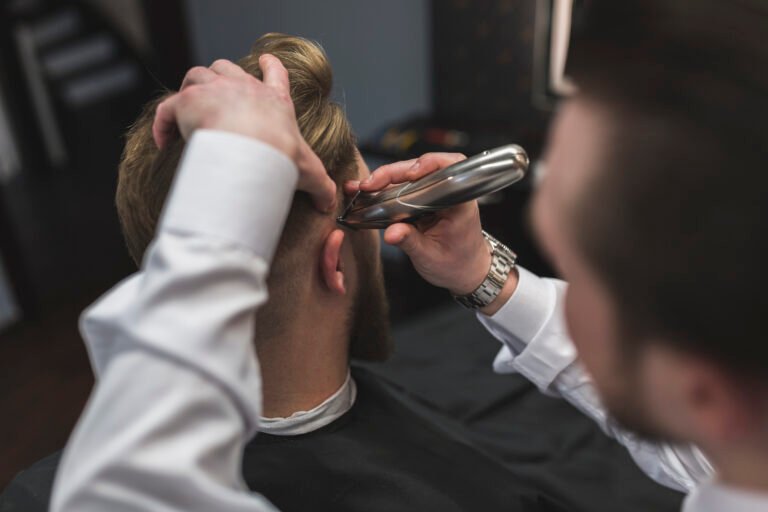 faceless-barber-shaving-hair-client-with-trimmer